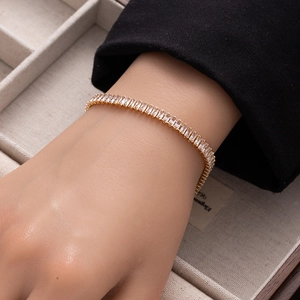 Close-up of golden tennis bracelet with rectangular clear cubic zirconia stones