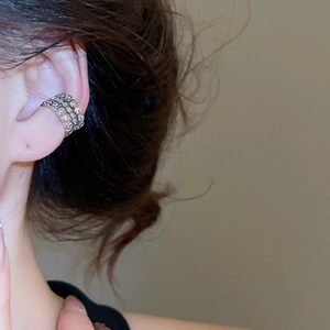 Detail view of silver multi-layer zircon ear cuff worn on ear cartilage without piercing