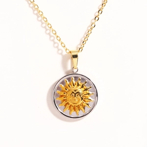 Macro detail of sun face relief pendant with silver ring and golden O-chain link