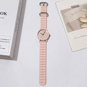 Close-up of pink quartz watch featuring a unique wavy silicone strap and minimalist dial