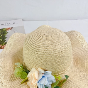 Detail of beige straw sun hat with floral decorations and wavy woven brim for summer beach