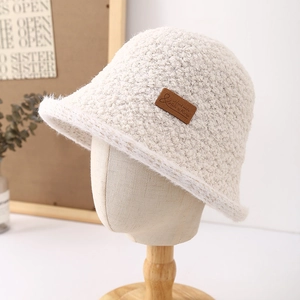 Chic beige faux shearling bucket hat with premium leather tag for winter warmth
