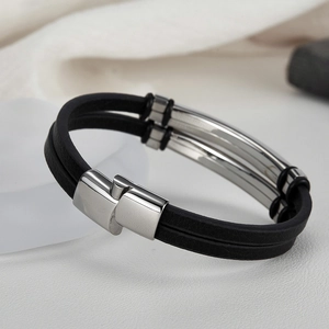 Detailed close-up of a double-layer black braided cord bracelet with polished steel buckle
