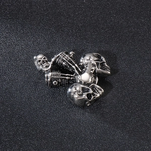 Detailed close-up of multiple silver stainless steel skull pendants for men jewelry