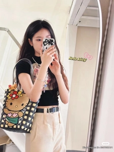 Detail of hand-woven checkerboard tote bag featuring Hello Kitty patch and matching phone case