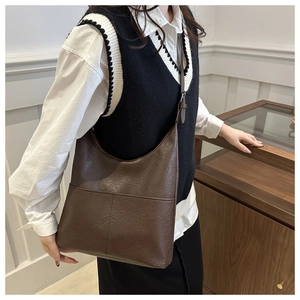 Mannequin portant un grand sac cabas marron foncé en similicuir montrant la taille