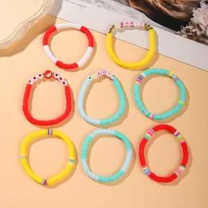 Flat lay of colorful Heishi bead bracelets with heart and beauty letter charms