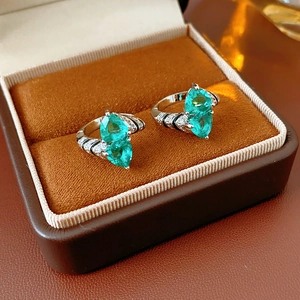 Detail of pear-cut green zircon rings with pavé accents in a brown velvet jewelry box