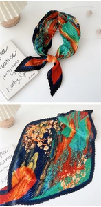 Detail of pleated silk scarf with oriental mountain landscape print in blue and orange