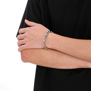 Polished silver stainless steel interlocking chain bracelet shown on a male wrist