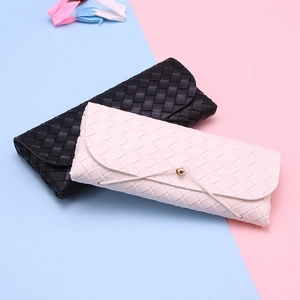 Detail showing woven leather texture and elegant bead drawstring closure on glasses cases