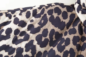 Nahaufnahme der Leopardenmuster-Textur einer dicken Steppjacke mit realistischen Details