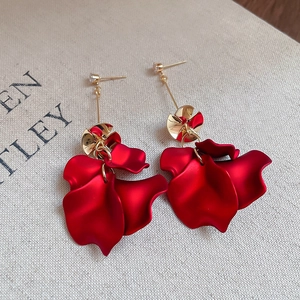 Detailed macro view of dark red velvet rose petal earrings with gold and zircon studs