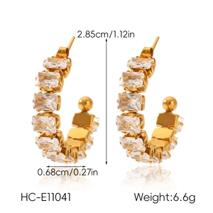 Detailed view of C-shaped gold earrings with zircon inlays and dimensions 2.85x0.68cm