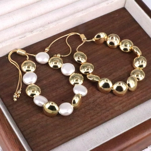 Dettaglio di bracciali con perle e sfere dorate e chiusura regolabile con cordoncino