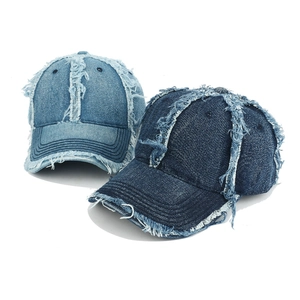 Detailed macro view showing distressed frayed edges on cotton denim baseball caps