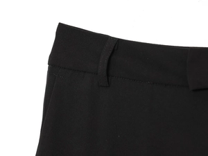 Detailed macro view of black trousers waist featuring fine stitching and belt loops