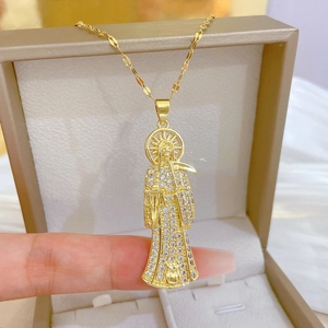 Detailed view of a gold grim reaper necklace with crystals in a beige jewelry box