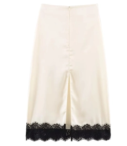 Detail of cream satin midi skirt with elegant black lace hem and back slit design