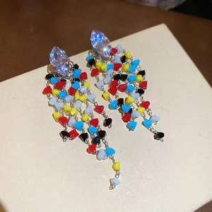 Detail view of rhombic zircon stud with colorful beaded tassels and dangling silver chains