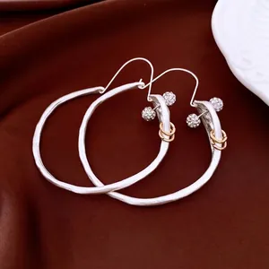 Retro round silver hoop earrings with diamond sphere and gold ring accents on silk