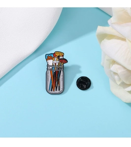 Artistic colorful paintbrush jar enamel pin with detailed metal brush and jar design