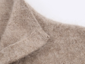 Dettaglio ravvicinato della maglia in mohair color cammello con bordo a costine