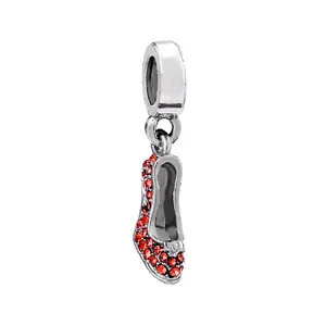 Detail of silver high heel charm with red rhinestones and a delicate bow decoration
