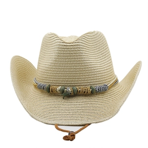 Detail of straw cowboy hat featuring beads, woven rope, and a metal starfish charm