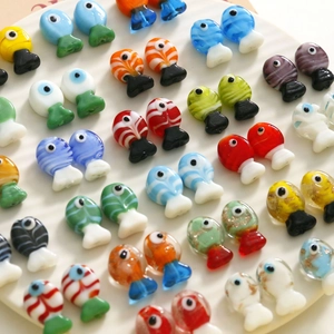 Macro view of colorful miniature glass fish beads for DIY jewelry making and crafts