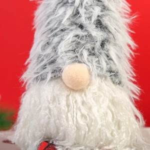 Macro shot of long-haired Christmas gnome with plush texture and festive red background