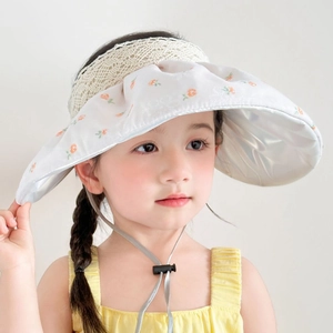 Detail of white floral sun visor with beige lace trim and adjustable wind rope