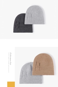 Detailed view of winter knit beanie showing criss-cross cable stitch patterns and warm textures