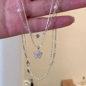 Three-layer silver necklace featuring pearl beads, blue crystal and a star pendant