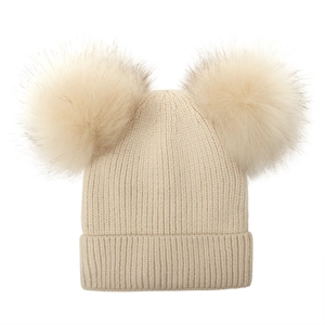 Close-up of cream knit beanie featuring dual fluffy faux fur pom-poms and ribbed texture