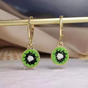 Detailed close-up of handmade enamel kiwi fruit earrings with gold plated frames