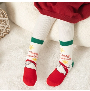 Dettaglio calzini natalizi per bambini con motivi di Babbo Natale in maglia e toni rossi