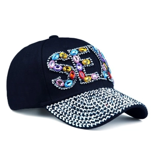 Detail of dark blue denim baseball cap with sparkling colorful rhinestones and SEX text