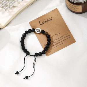 Detailed shot of handmade Cancer zodiac beaded bracelet with tiger eye stone and gift card