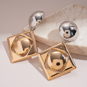 Detail of geometric metal earrings with square and round mixed gold and silver design
