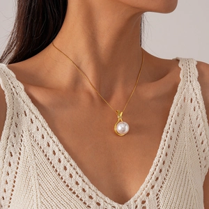 Close-up of elegant gold pearl pendant necklace with zircon inlay on a female model