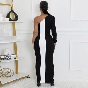 Détail d'une robe moulante asymétrique noir et blanc avec ornements métalliques