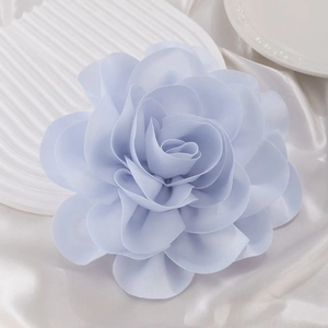 Close-up of light blue silk rose fabric flower with soft multi-layered petal textures