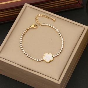 Detail of gold flower bracelet with white shell petals and sparkling zircon stones