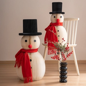 Two origami honeycomb paper snowmen with red scarves for Christmas tabletop decoration