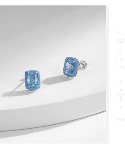 Macro view of silver studs with rectangular blue stones and enamel accents on white steps