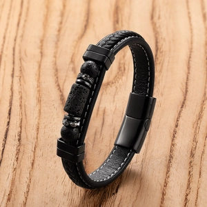 Detail of woven black leather bracelet with magnetic clasp and natural volcanic stone beads