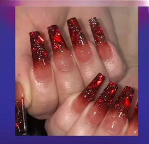 Macro shot of coffin-shaped ombre nails in black and red with rhinestones