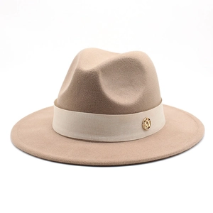 Macro view of light camel wool fedora hat featuring a beige grosgrain ribbon and gold logo