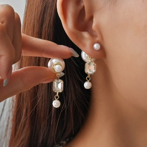 Elegant gold bow multi-layer faux pearl and crystal earrings for woman shown on ear